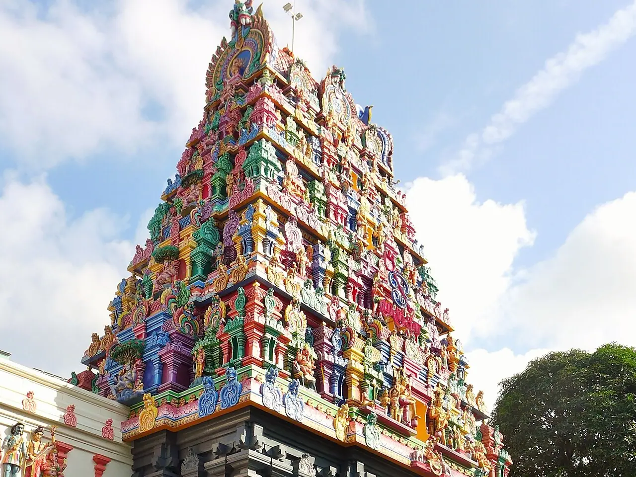 సింగపూర్‌లోని ట్యాంక్ రోడ్‌లో ఉన్న శ్రీ తెందాయుధపాణి ఆలయంలో బూడిద రంగు రాతి పీఠంపై రంగురంగుల దక్షిణ భారత గోపురం; ప్రవేశద్వారం వద్ద చెప్పుల అరలు, మెట్లు